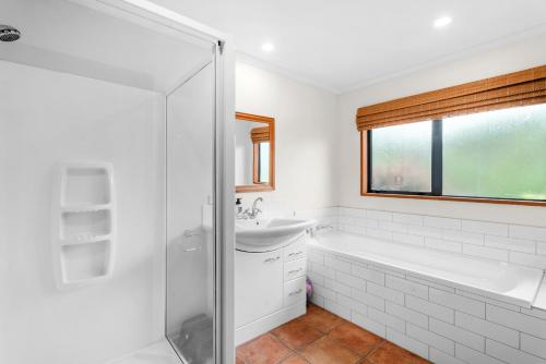 a bathroom with a tub and a sink and a shower at Hāwea Delight - Lake Hāwea Holiday Home in Lake Hāwea