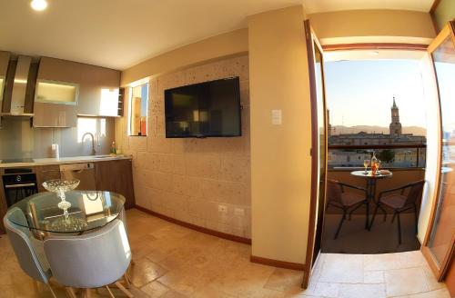 una cocina y un comedor con una mesa y una cocina y una habitación con en ARIQUEPAY HOTEL, en Arequipa