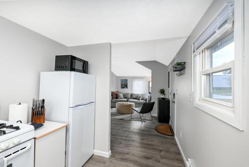 a kitchen with a white refrigerator and a living room at Recharge and Reconnect Your cozy Vermilion nest in Vermilion