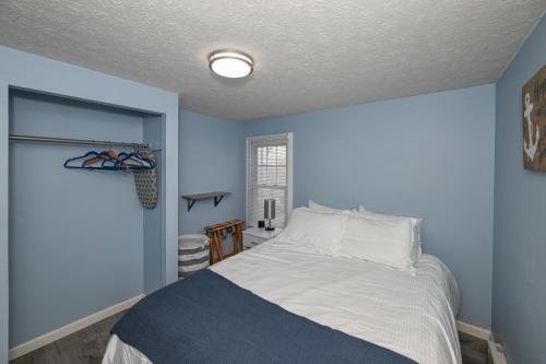 ein blaues Schlafzimmer mit einem Bett und einem Fenster in der Unterkunft Recharge and Reconnect Your cozy Vermilion nest in Vermilion