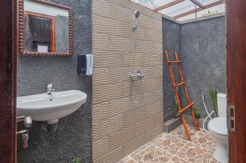 a bathroom with a shower and a sink and a toilet at Maskot Penida Cottage in Nusa Penida