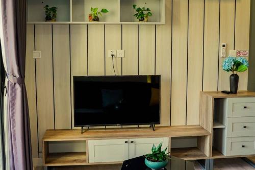 a flat screen tv sitting on a wooden entertainment center at The Origami: Exclusive Living ! in Long Bình