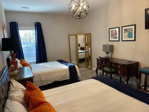 a bedroom with two beds and a desk and a mirror at Adorable Apt with Access to Pool and Tennis Courts in Dallas