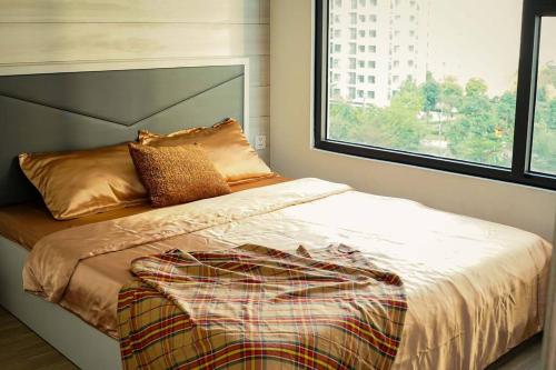 a bed in a bedroom with a large window at The Origami: Exclusive Living ! in Long Bình
