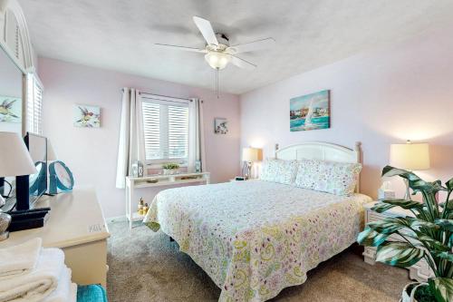a bedroom with a bed and a ceiling fan at Captain's Villa 9-C Sunshine Ally in Holden Beach