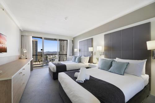 a hotel room with two beds and a balcony at Ocean View Studio with Rooftop Jacuzzi in Gold Coast