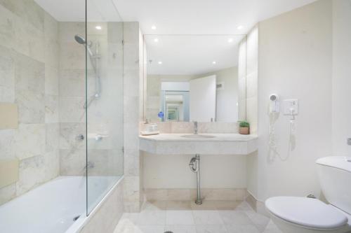 a bathroom with a shower and a sink and a toilet at Ocean View Studio with Rooftop Jacuzzi in Gold Coast