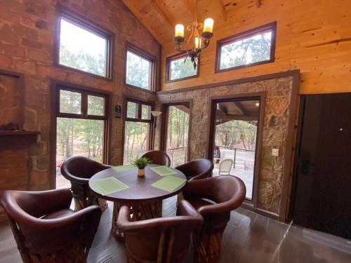 una sala da pranzo con tavolo e sedie in pelle di Providencia PREMIUM Cabañas del Lago - Luciérnaga a Los Alamillos