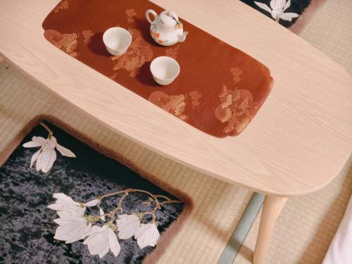 a wooden table with a bowl of syrup on it at Rest collection Gion-Shijo Kyoto in Kyoto
