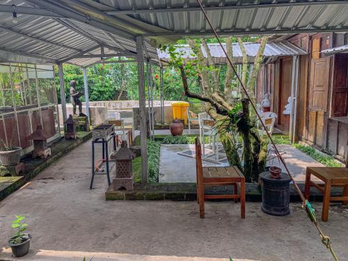 a greenhouse with a table and chairs and a tree at Carla Garden Villa in Yogyakarta