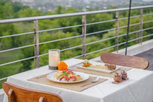 a table with two plates of food and a candle at Akhyana Village in Jimbaran