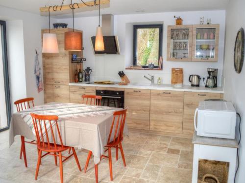 une cuisine avec une table, des chaises et un comptoir dans l'établissement Gîte douillet à Luzillé avec terrasse, jardin, climatisation, proche Château de Chenonceau et Zoo de Beauval - FR-1-381-513, à Luzillé