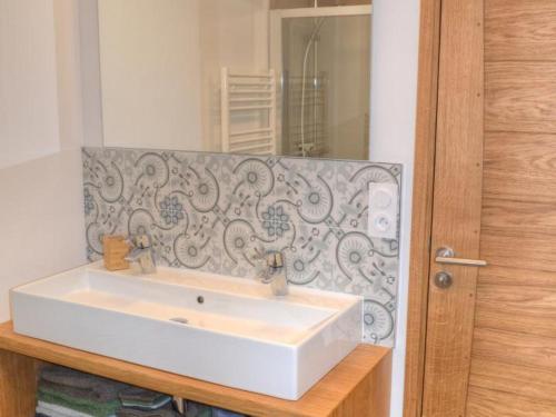 y baño con lavabo blanco y espejo. en Gîte Luzillé, 2 pièces, 3 personnes - FR-1-381-513, en Luzillé