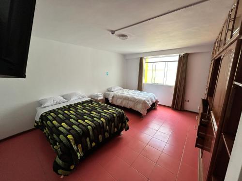 um quarto com 2 camas e um piso vermelho em Recreo Beach em Huanchaco