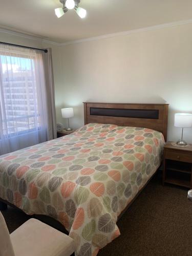 サンティアゴにあるDepartamento LA FLORIDAのベッドルーム1室(ベッド1台、ランプ2つ、窓付)
