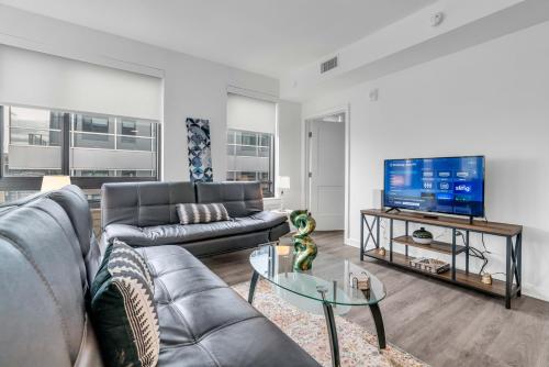 sala de estar con sofá y TV en Waterfront Two Bedroom apartment in a brand new building apts, en Washington