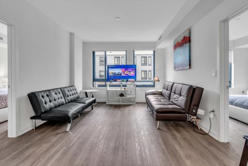uma sala de estar com duas cadeiras de couro e uma televisão em Two Bedroom Fully Furnished Apartment near Waterfront apts em Washington