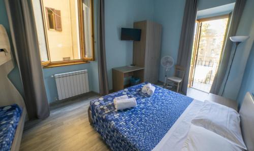 a bedroom with a blue and white bed and a window at B&B Porta Livorno in Civitavecchia
