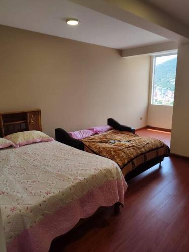 - une chambre avec 2 lits et une grande fenêtre dans l'établissement hermoso departamento confortable tribeca, à Cochabamba