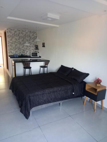 1 dormitorio con 1 cama y 1 mesa en una habitación en Suíte do Betão en Mangaratiba