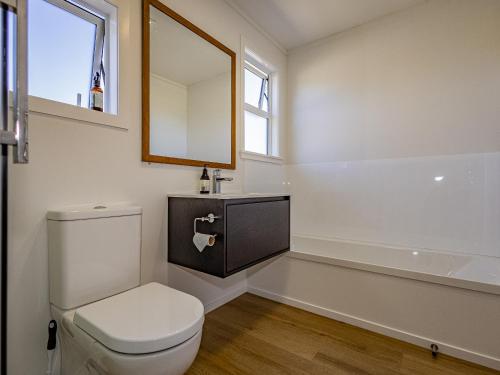 a bathroom with a toilet and a sink and a mirror at Alpine Rest - National Park Holiday Home in National Park