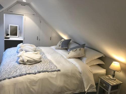 a bedroom with a large white bed with pillows at The Hut- Private 1 Bed Guesthouse in Lymington Town Centre, garden & parking in Lymington