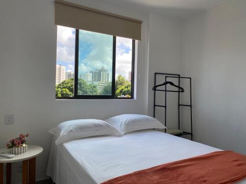een slaapkamer met een wit bed en een raam bij Apt novíssimo Tamarineira in Recife