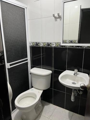 a bathroom with a toilet and a sink at Hotel Villa Sofia in Villavicencio