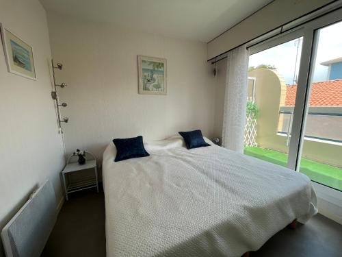ein Schlafzimmer mit einem Bett mit zwei blauen Kissen darauf in der Unterkunft Appartement Arcachon, 2 pièces, 4 personnes - FR-1-374-115 in Arcachon