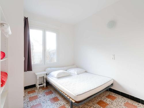 un lit dans une chambre avec une fenêtre dans l'établissement Appartement T2 en RDC, 6 pers, Narbonne-Plage, 100m de la mer, animaux OK, cuisine équipée, WiFi - FR-1-409-149, à Narbonne