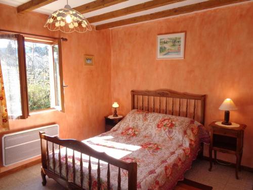 a bedroom with a bed and a window and a chandelier at Gîte Saint-Haon-le-Châtel, 4 pièces, 6 personnes - FR-1-496-21 in Saint-Haon-le-Châtel