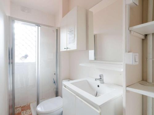 une salle de bain blanche avec des toilettes et un lavabo dans l'établissement Appartement T2 en RDC, 6 pers, Narbonne-Plage, 100m de la mer, animaux OK, cuisine équipée, WiFi - FR-1-409-149, à Narbonne