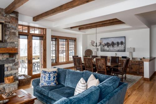 a living room with a blue couch and a table at Luxury Suite 6A by Moonlight Basin Lodging in Big Sky