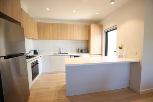 a kitchen with white cabinets and a white counter top at Hamilton By the Bay 3 Newly Built in Safety Beach