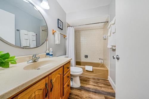 a bathroom with a sink and a toilet and a mirror at Modern Lake Geneva Condo with Year-Round Views in Lake Geneva