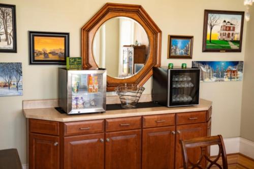 - une commode avec un miroir et une télévision dans l'établissement The Victorian Guesthouse, à Delphos