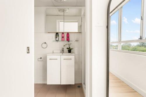 una cucina bianca con lavandino e finestra di Chic Studio with a Pool and Moments from Shop a Sydney