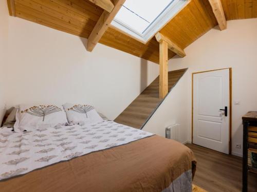 een slaapkamer met een groot bed en een dakraam bij Gîte Saint-Jean-Soleymieux, 4 pièces, 8 personnes - FR-1-496-313 in Saint-Jean-Soleymieux
