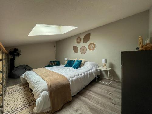 une chambre avec un grand lit avec des oreillers bleus dans l'établissement Duplex convivial à Saint-Cyprien - 4 couchages - Plage & commerces à pied - FR-1-753-16, à Saint-Cyprien