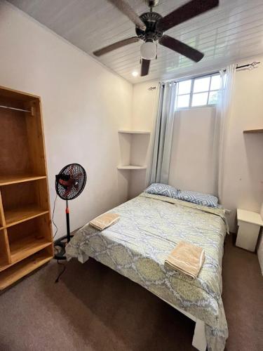 een slaapkamer met een bed en een plafondventilator bij Melody's Modern Apartment #2 in Puerto Limón