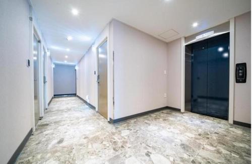 an empty hallway of an office building with doors and tile floors at Y Motel in Busan