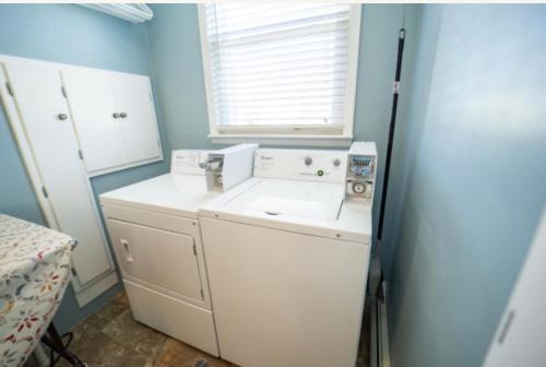 a laundry room with a sink and a washer at The Victorian Guesthouse in Delphos