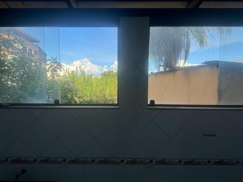 two windows in a room with a view of a building at Apart Hotel big john 101 Vista para rua in Divinópolis