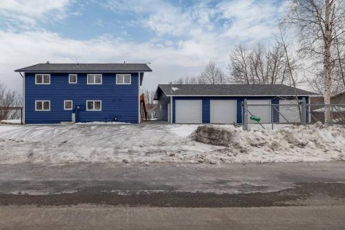 a blue house in the snow in front at Top floor lakefront condo with Mountain Views! in Wasilla