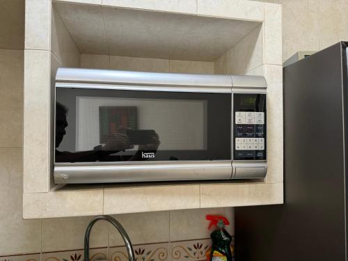 a microwave in a wall in a kitchen at Acapulco diamante departamento con playa ecológico in Acapulco