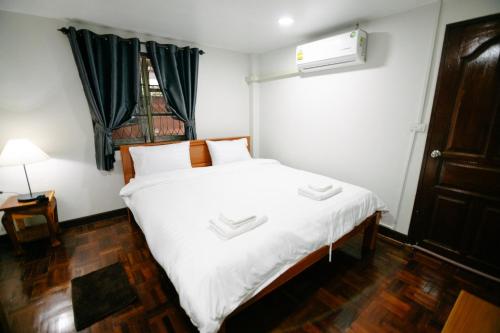ein Schlafzimmer mit einem weißen Bett und einem Fenster in der Unterkunft Nadee House in Ban Pa Sang (1)
