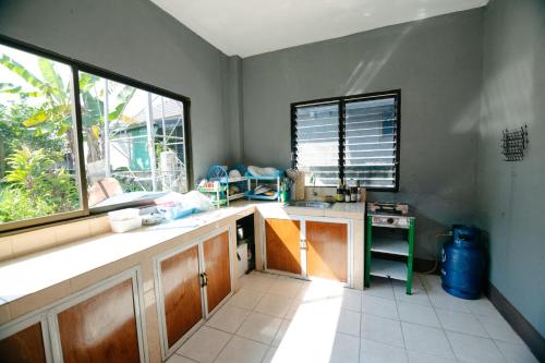 eine Küche mit einer Theke, einem Waschbecken und einem Fenster in der Unterkunft Nadee House in Ban Pa Sang (1)