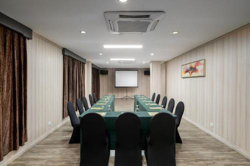 a conference room with a green table and chairs at Sunlight Hotel Puerto Princesa in Puerto Princesa City