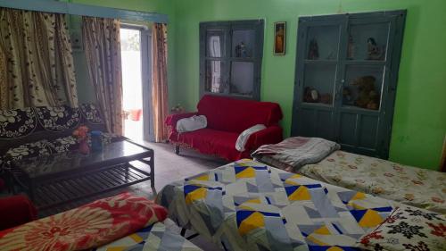 ein Wohnzimmer mit 2 Betten und einem Sofa in der Unterkunft Karunanidhan Homestays in Ayodhya