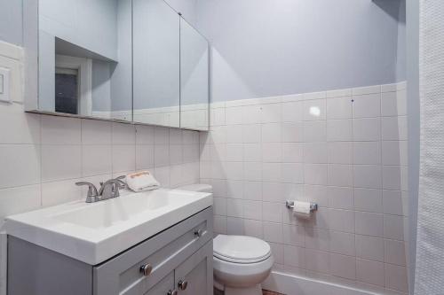 a white bathroom with a sink and a toilet at 2 MTM Fully Furnished Rental in Old Town 2f&2r in Chicago